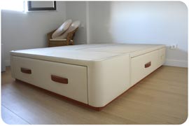 Cama cajones Plus tapizada polipiel color crudo con tiradores y zócalo color cerezo montada en Madrid