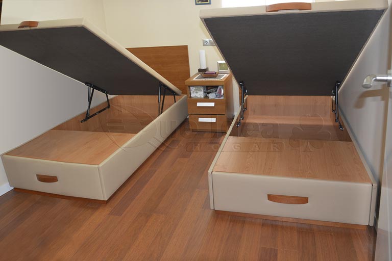 Dos canapés de tapa abatible con cajones de 90cm de ancho por 200 de largo tapizados en color beige con tiradores color cerezo