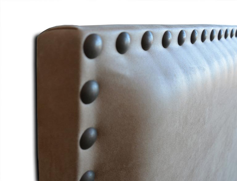 Detalle del cabecero tapizado modelo Sevilla con tachuelas broce