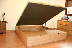 Cama de madera de tapa abatible con cajones en el frontal de la cama