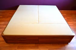 Perspectiva desde los pies de la cama o canapé de madera con dos cajones