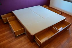 lado izquierdo de la cama de madera con cajones en Madrid