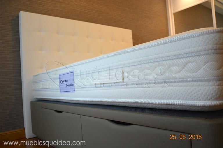 Viscorrelax puesto junto con una cama con cajones tapizada en polipiel de color gris