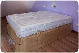 Colchón Viscorrelax en su bolsa de plástico con cama tapada con cartón montado en obra