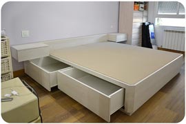 Canapé con cajones con mesitas de noche colgadas de la pared